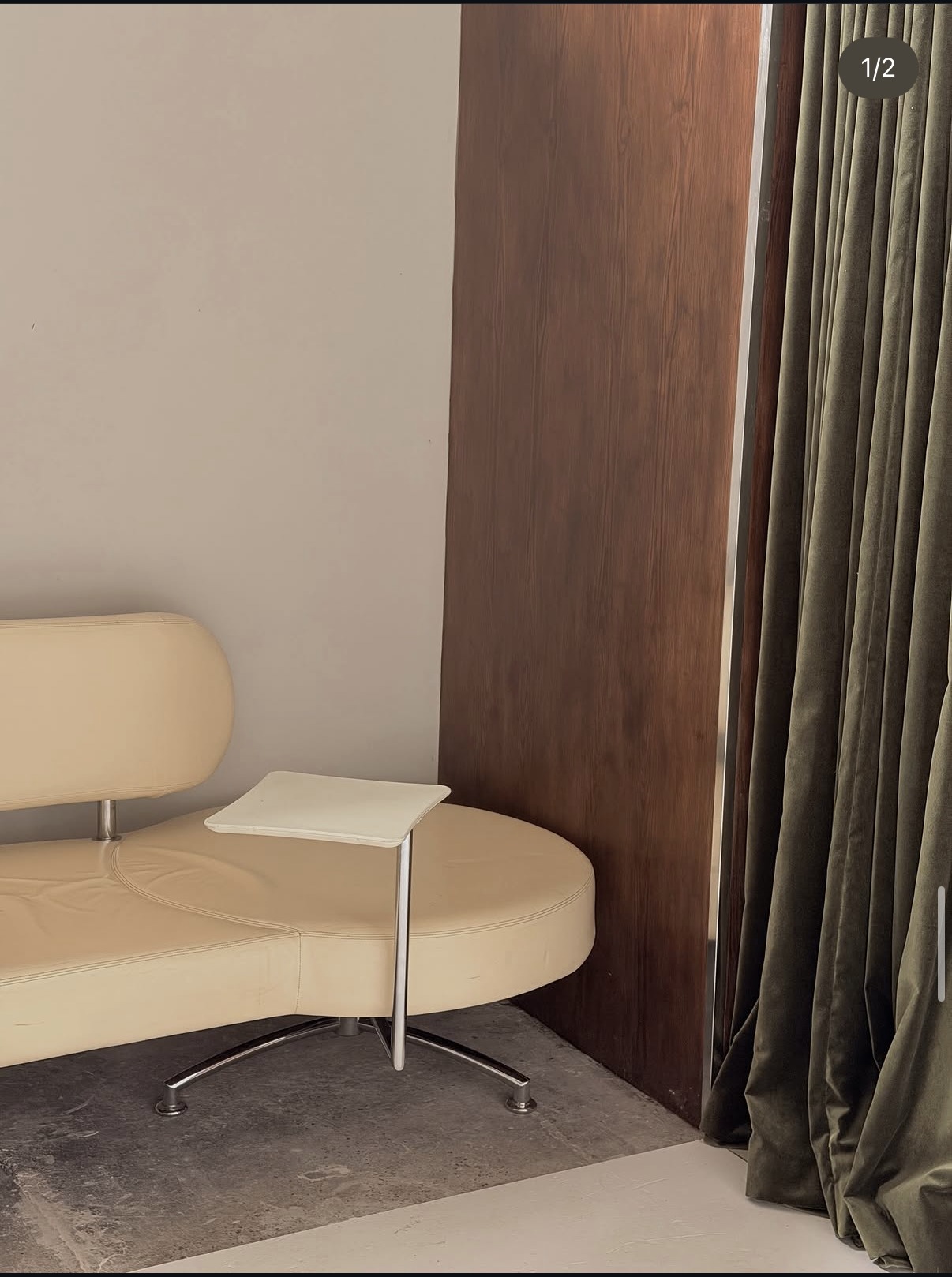 Cream lounge sofa with olive curtain and walnut panel.